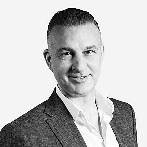 Vertriebsmitarbeiter Ioannis Valissaris | Camlog Schweiz Portraitbild des Mitarbeiters in schwarz-weiß, Ioannis Valissaris